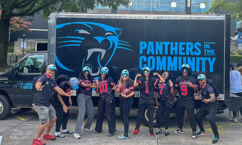  Members of David W. Butler's flag football team poses in front of Panther's trailer